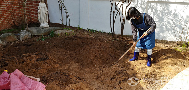 공유정원 자원봉사자가 모퉁이쉼터 마당에 식물을 심기 위해 두둑을 만들고 있다. ⓒ배선영 기자