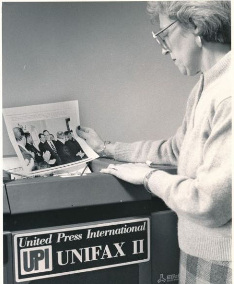 CNS의 사진편집자인 바버라 스티븐슨이 또 다른 일반통신사인 UPI의 사진전송기 Unifax II에서 사진을 받고 있다.(1990) CNS는 교회 밖 소식은 AP, UPI 등을 구독하여 받아썼다.&nbsp;(사진 출처 = CNS)<br>