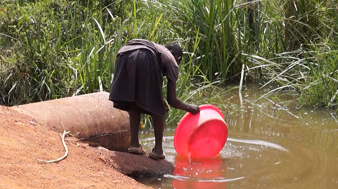 식수가 부족해 웅덩이 물을 기르는 우간다 루웨로 지역 아동. (사진 제공 = 한국희망재단)<br>