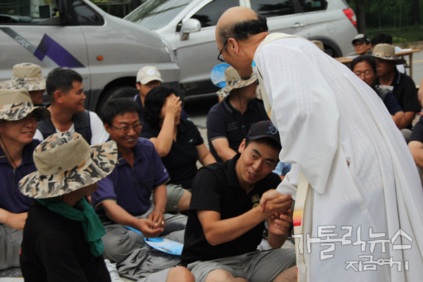 미사 도중에 최영민 신부가 유성기업 노동자들과 평화의 인사를 나누고 있다.(사진/한상봉 기자)