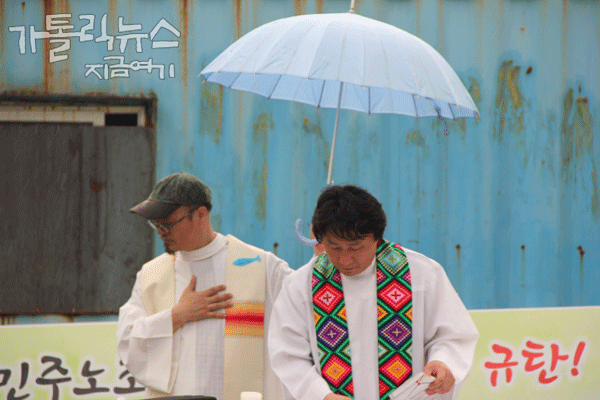 미사 끝무렵에 갑자기 소나기가 내렸다.(사진/한상봉 기자)