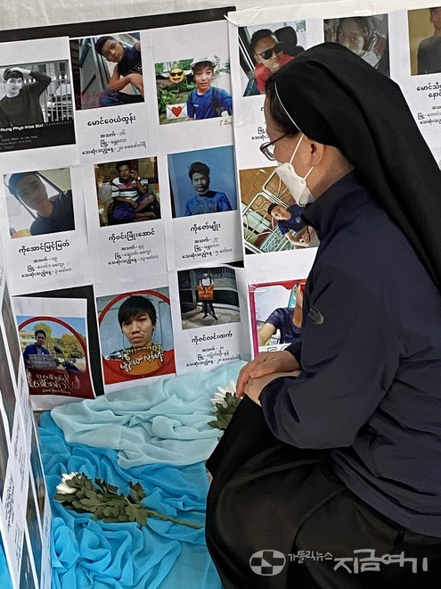 미얀마 군부에 희생된 이들의 사진 앞에 헌화하며 기도하는 수도자. ⓒ정현진 기자