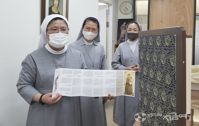 편지의 번역문이 담긴 리플릿으로 병풍을 설명하는 이선중 수녀. ⓒ김수나 기자 