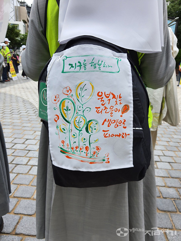 순례단에 참여한 한 수녀의 가방에 '지구를 행복하게' 메시지가 적혀 있다. ⓒ김수나 기자<br>