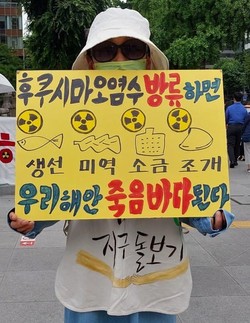 6월 23일 가톨릭기후행동의 금요기후행동에 나선 한 참여자가 오염수 방류 반대 손팻말을 들고 있다. (사진 제공 = 가톨릭기후행동)