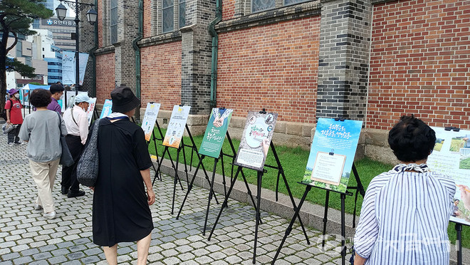 17일 명동대성당 앞마당 농민 주일 행사에서 미사가 끝나고 나온 신자들이 식량 위기의 심각함을 알리는 내용의 전시를 보고 있다. ⓒ배선영 기자