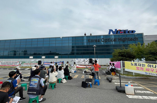 5월 27일 구미 공장 앞 연대 미사. 건물 위 고공 농성 중인 두 노동자와 인사를 나누고 있다. (사진 제공 = 부산교구 노동사목위원회)<br>