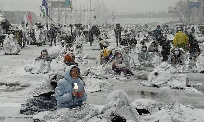 지난 5일 눈 내린 아침, 전날부터 '윤석열 체포' 시위를 벌인 시민들이 '키세스' 초콜릿을 연상시키는 비상 은박 담요 덮으며 밤을 지새웠다. (사진 출처 = 정혜경 진보당 의원실)