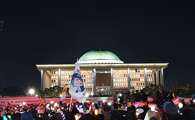 윤석열 대통령 탄핵 표결이 있던 지난해 12월 7일,&nbsp;국회의사당 앞에서 시민들이 탄핵 시위하는 모습. (사진 출처 =&nbsp;&nbsp;commons.wikimedia.org)