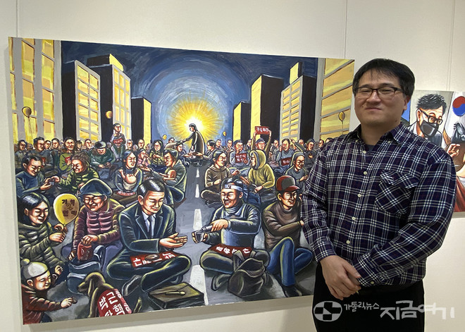 작품 '오병이어' 옆에 선 최형규 작가. 그는 박근혜 탄핵 당시 집회 현장의 연대를 '오병이어' 기적으로 표현했다. ⓒ정현진 기자<br>