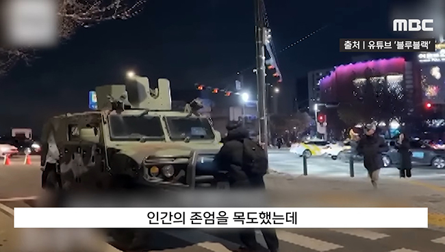 2024년 12월 3일 비상계엄이 선포된 밤, 김동현 씨(민달팽이유니온 회원)는&nbsp;택시 타고 국회의사당으로 달려갔다. 계엄 해제 의결된 뒤인 2시 넘어서도 윤석열 대통령이 해제 선언하지 않았고, 국회 방향으로 돌아오는 군용 차(5602 부대)를 보자&nbsp;진입하지 못하도록 혼자 막아섰다. 이를 본 시민들이 곧 달려와 함께 막았고 교통경찰에 항의해 군용 차가 방향을 돌리게 했다. (사진 출처 = MBC NEWS가 유튜브 채널에 올린 동영상 갈무리)