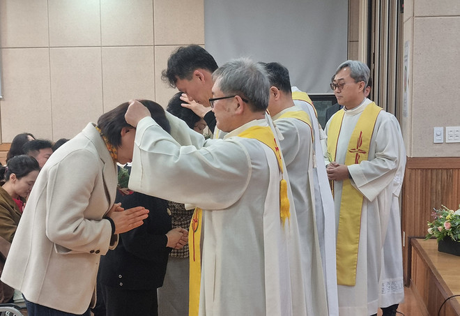 민들레 서원자 4명이 서원을 마치고, 길벗 사제들에게서&nbsp;안수를 받고 있다. (사진 제공 = 예수살이공동체)<br>